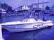 1979 Ford F-250 - A boat named Mister E is seen with two occupants in a marina, with houses and cars visible on the shore.
