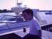 1979 Ford F-250 - A young boy sits on a dock, shielding his eyes as he looks out at boats on the water.