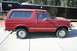 1989 Ford Bronco - Side profile of a red 1989 Ford Bronco parked on a concrete surface.