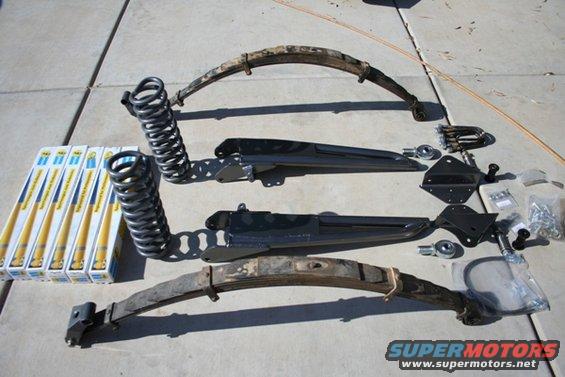 Suspension parts including leaf springs, coil springs, and shock absorber boxes on concrete