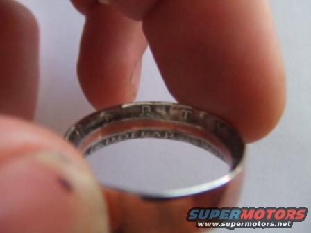 Ring made from a coin, showing text 'ONE DOLLAR' and other markings