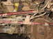 1991 Ford Bronco - Undercarriage view showing red suspension components and chains, covered in mud.
