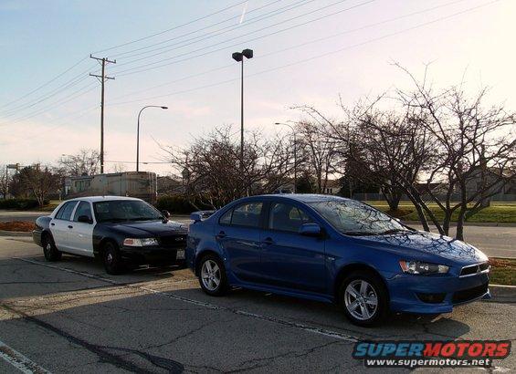 2009 Mitsubishi Lancer parked next to a police car