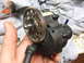 1996 Ford Bronco - Close-up of a toy bronco gearbox with a large metal gear, held by a hand.