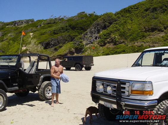 Black Jeep Wrangler on beach, 3q-front view. 1995 Jeep Wrangler
