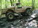 1988 Ford Bronco - This heavily modified pickup truck is shown off-roading on a challenging rocky path.