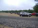 1988 Ford Bronco - A variety of vehicles are parked in an outdoor lot under an overcast sky.