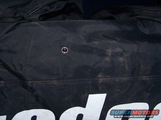 Black gear bag with partial white lettering and a metal snap