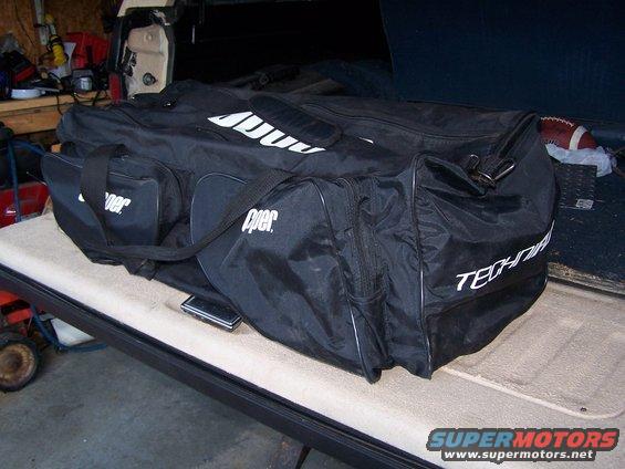 Black duffel bag with white lettering on vehicle interior
