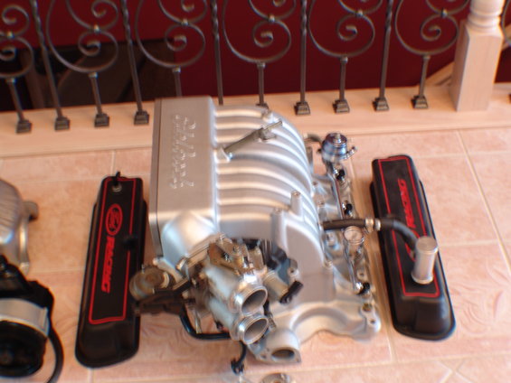 Silver intake manifold with red and black valve covers reading 'RACING'