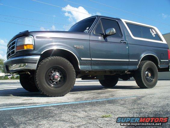 Gray Ford Bronco with a white top, parked outside
