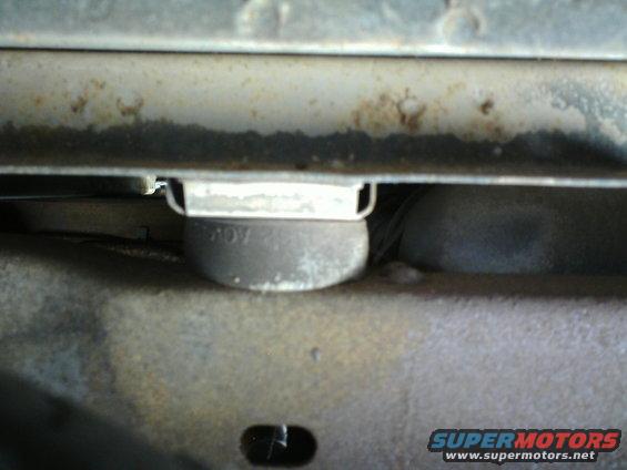 Undercarriage view of a vehicle part with "ROY" visible, showing rust and wear