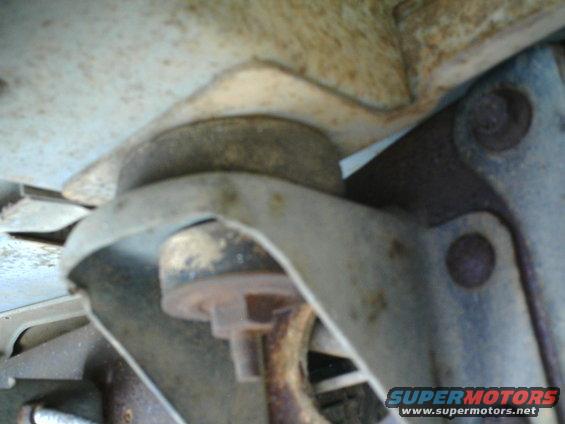 Close-up of a vehicle's suspension mount with visible rust