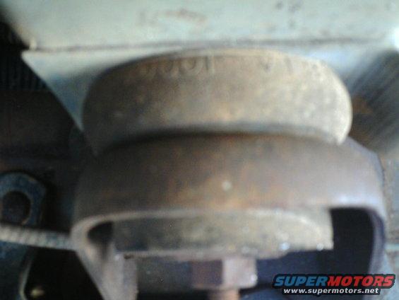 Close-up of a rusty engine mount with visible bolt and bracket