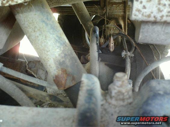 Undercarriage view showing suspension parts, leaf springs, and brake lines