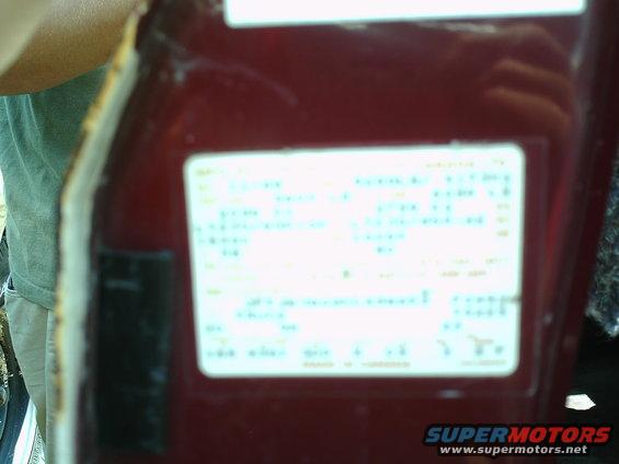 Close-up of a vehicle identification sticker on a red surface
