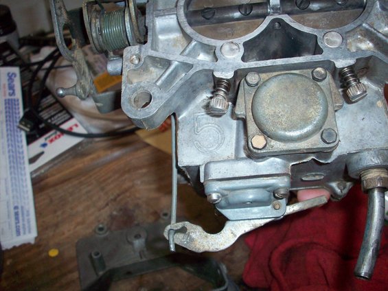 Close-up of a carburetor with a large number 5 stamped on the side