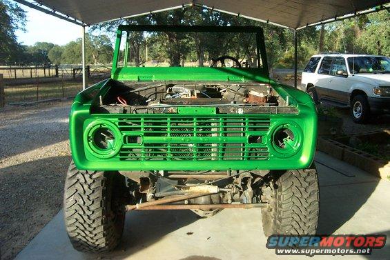 Green 1976 Ford Bronco front view, hood open, undergoing restoration