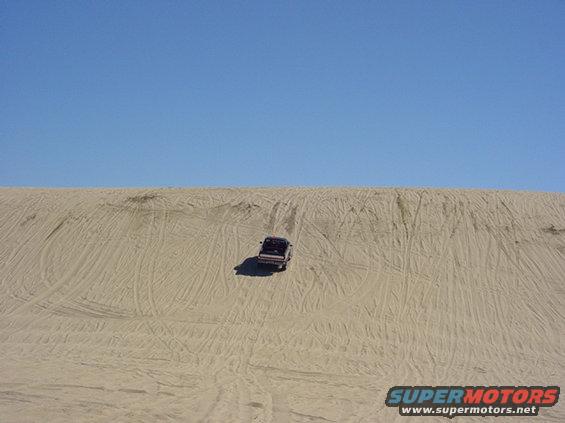 1995 Jeep Wrangler driving up a sand dune