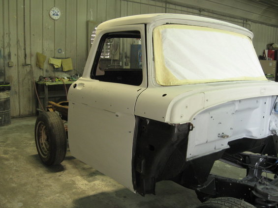 1966 Ford F-100 cab, primed and masked for paint, in a workshop
