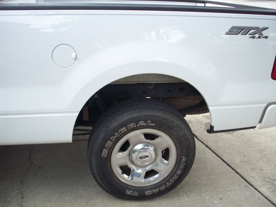 White Ford F-150 STX 4x4 pickup truck rear wheel well with a General Ameritrac TR tire