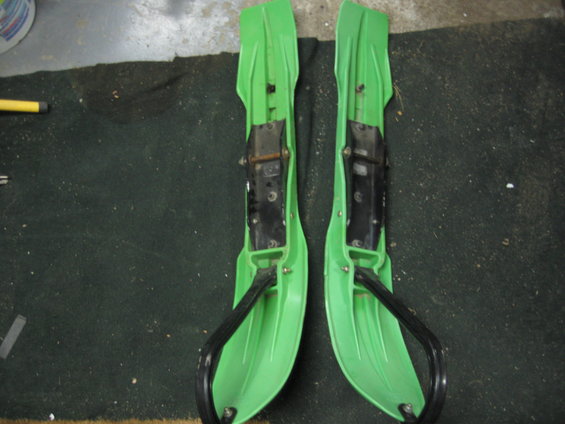 1 pair of green Parabolic skis, with mounts/hoops. One has a nick on the outside edge. There is still lots of life left in these skis - $100