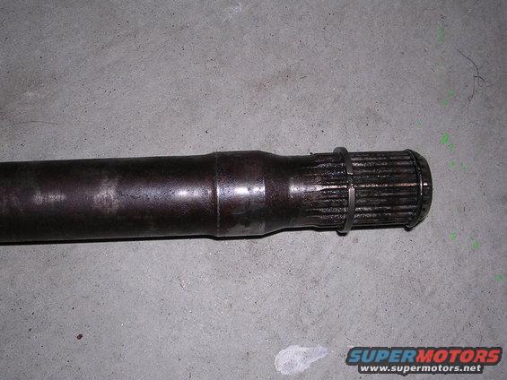 Driveshaft part with splines and a retaining ring on a concrete floor
