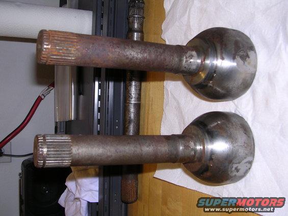 Two rusty axle shafts with splined ends and spherical joints