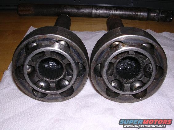 Two constant velocity joints with splined inner bores, and a driveshaft in the background