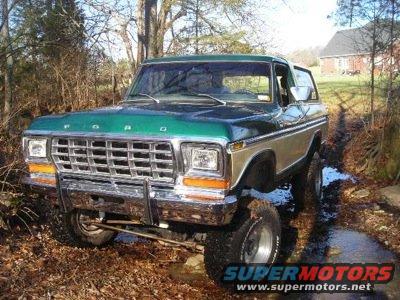 Green and tan 1979 Ford Bronco with lifted suspension on a dirt path