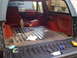 1988 Ford Bronco - The cargo area of an SUV is shown with tools laid out on the tailgate, ready for work.