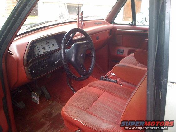 1988 Ford Bronco interior with red seats, dashboard, and steering wheel