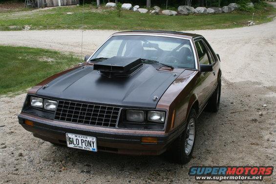 Brown 1980 Ford Mustang coupe with black hood and scoop, front 3/4 view