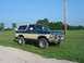 1979 Ford Bronco - Two-tone green and tan 1979 Ford Bronco in a grassy field.