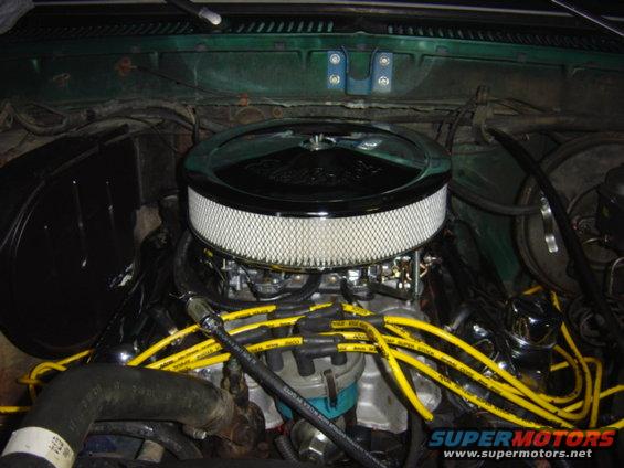 Engine bay with a chrome air filter housing and yellow spark plug wires