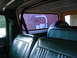 1979 Ford Bronco - Interior view of a green vehicle, showing the bench seats and a spare tire mounted behind them.