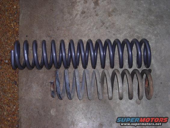 Two coil springs, one dark gray and longer, the other lighter gray and shorter with rust