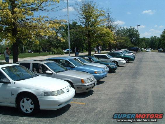 White 1993 Ford Taurus front 3/4 view, parked in a line with other cars