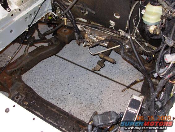 Engine bay frame with wiring and hoses, viewed from above