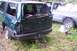 2004 Arctic Cat F-7 Firecat - Rear view of a damaged green Ford Explorer parked next to a pickup truck in a grassy area.