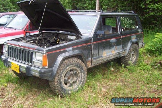Black Jeep Cherokee with hood open, showing engine. Text on window reads "$800 773-120"