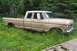 2004 Arctic Cat F-7 Firecat - This weathered pickup truck appears to be a 1970s model, parked in a grassy area with yellow wildflowers.