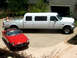 1970 Mercury Cougar - A white limousine truck with a hot tub in its bed is parked next to a red convertible.