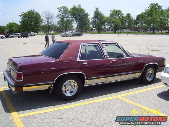 Maroon sedan parked in a lot, side view, chrome trim, aftermarket wheels