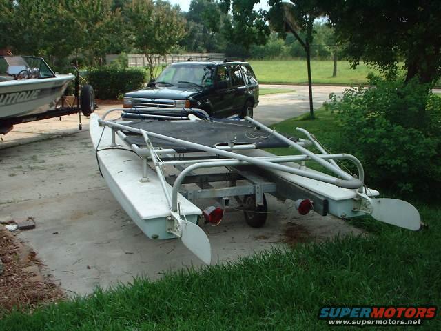Black SUV parked next to a boat on a trailer. The SUV appears to be a 1996 Ford Explorer