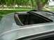 2001 Ford Expedition - A silver SUV is parked outdoors, with its sunroof open, revealing the interior and a glimpse of the surrounding park.