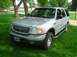 2001 Ford Expedition - A silver 2001 Ford Expedition is parked on a green lawn under a partly cloudy sky.