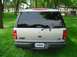 2001 Ford Expedition - The rear of a silver 2001 Ford Expedition is visible parked on grass with trees in the background.