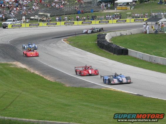 Race cars on track with spectators in background