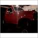 1994 Ford F-250 - A red pickup truck is parked inside a garage, with its front portion illuminated.